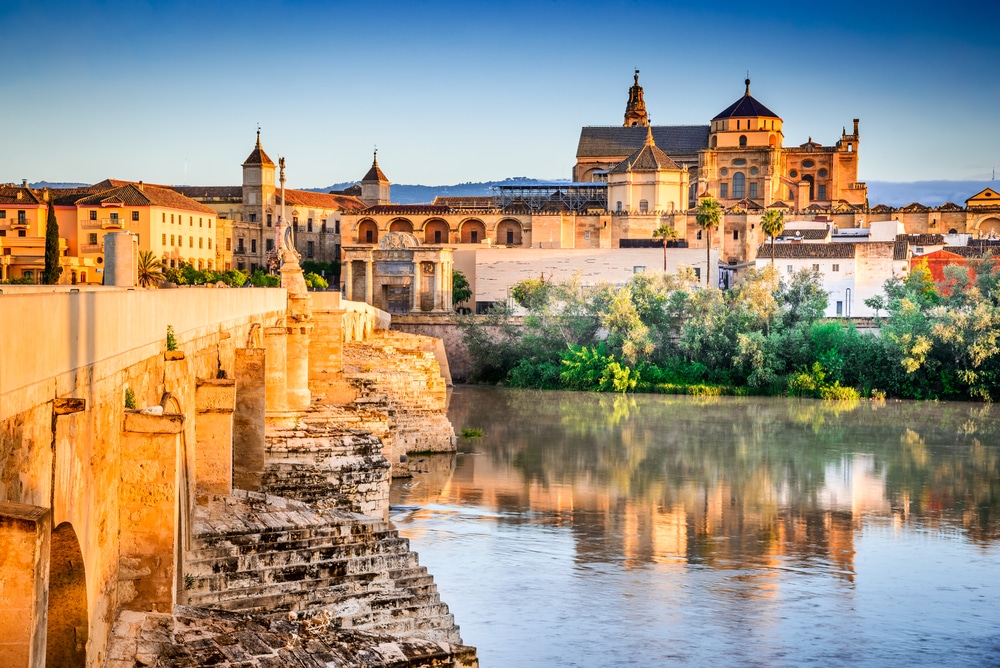 Römische Brücke am Fluss Guadalquivir und die Große Moschee (Mezquita Kathedrale) in der Stadt Córdoba, Andalusien.