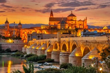Evening view of the mosque-cathedral with Roman bridge in Cordoba